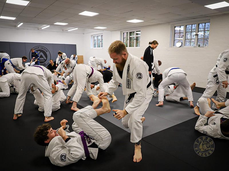 Adult students training together at RGA Buckingham, smiling and enjoying a friendly Jiu-Jitsu session on the mats.